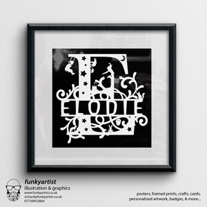 Puede incluir: Una obra de arte enmarcada en blanco y negro con el nombre "ELODIE" en una fuente decorativa. El dise&ntilde;o incluye una letra "E" adornada con ilustraciones caprichosas de ni&ntilde;os, estrellas y una luna. El marco es negro y la obra de arte se exhibe en una pared blanca. El logotipo y la informaci&oacute;n de contacto del artista est&aacute;n en la esquina inferior izquierda.