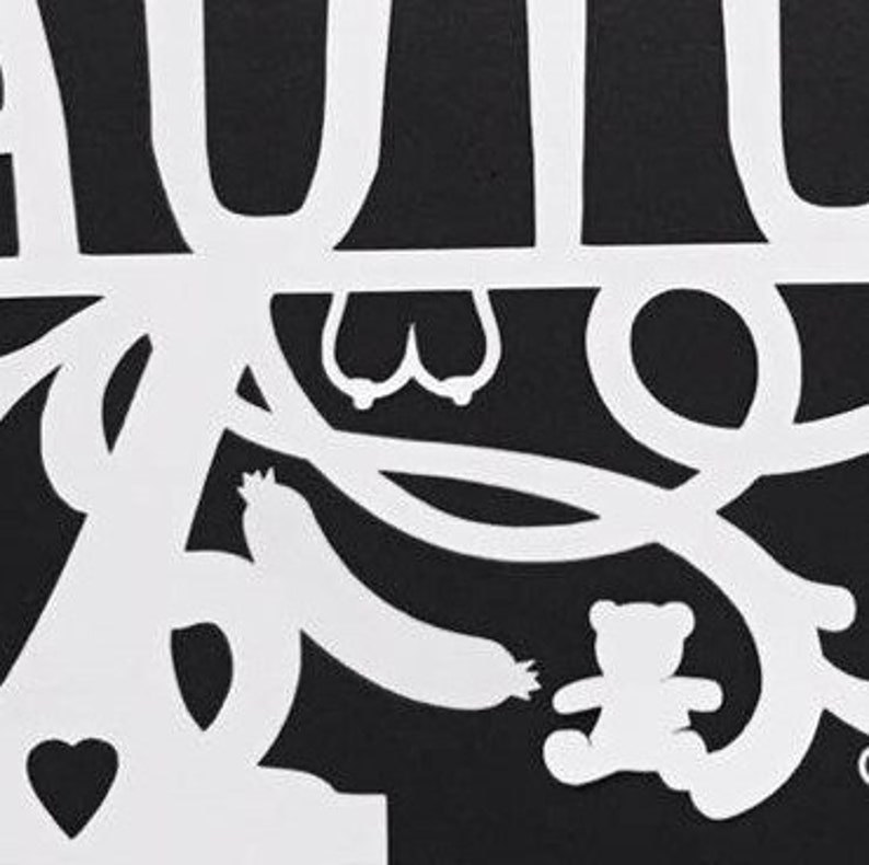 Puede incluir: Un dise&ntilde;o recortado en papel en blanco y negro que presenta un &aacute;rbol con la palabra "AUTUMN" en la parte superior. El dise&ntilde;o incluye un coraz&oacute;n, un calabac&iacute;n y un osito de peluche. La imagen es un primer plano del recorte de papel.