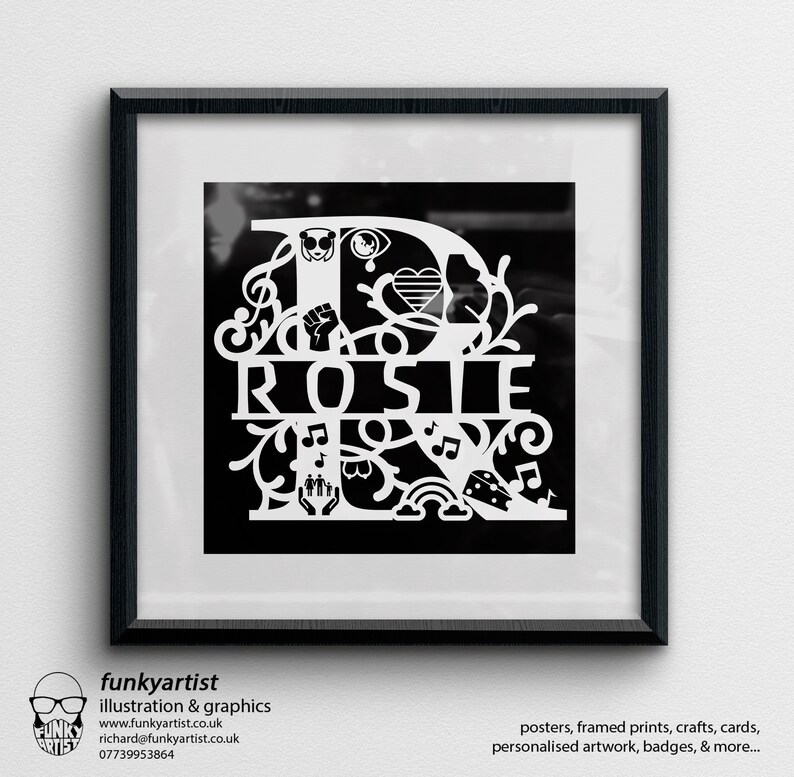 Puede incluir: Una impresi&oacute;n art&iacute;stica en blanco y negro enmarcada con el nombre "Rosie" en una fuente decorativa. El dise&ntilde;o incorpora varios s&iacute;mbolos, incluyendo notas musicales, un arco&iacute;ris y un coraz&oacute;n. El marco es negro y la impresi&oacute;n est&aacute; en una pared blanca.