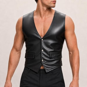 May include: A black sleeveless vest featuring a deep V-neckline, a smooth finish, and three silver-toned metal snap buttons down the center front. The garment includes two rectangular flap pockets on the lower front and a pointed hemline.