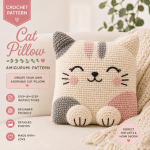 May include: A crocheted cat pillow with a smiling face, gray ears, and pink accents. The pillow is cream-colored and has a cute design. The image includes text that says "Cat Pillow" and "Amigurumi Pattern".