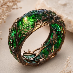 May include: A wide ring featuring a dark bronze-toned metal frame shaped like intricate tree branches. The center of the band is filled with a vibrant, translucent emerald green material that has a textured, crystalline appearance throughout.