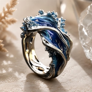 May include: A silver-toned ring featuring a fluid, wave-like design with deep blue and light blue enamel detailing. The band has an organic, sculptural shape with small, textured bead-like accents along the edges that mimic sea foam.