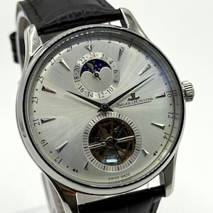 Può includere: Un orologio da polso Jaeger-LeCoultre color argento con quadrante a raggiera, cinturino in pelle nera e indicatore delle fasi lunari. Il quadrante presenta un movimento tourbillon visibile a ore sei, indici argentati e il nome del marchio.