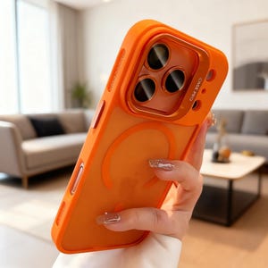 May include: A bright orange smartphone case with a matte finish and a matching orange camera lens protector frame. The case features a circular magnetic ring design on the back and the text CASE PRO printed near the camera module area.