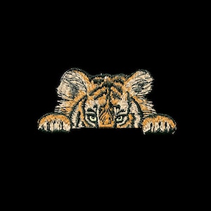 May include: Embroidered tiger patch with orange and black stripes, green eyes, and tan fur. The tiger's head and paws are visible, peeking out from the bottom. The patch is on a black background.