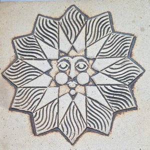 May include: A square, beige ceramic tile with a carved sun design. The sun has a face with closed eyes, a nose, and a mouth. The sun's rays are stylized with wavy lines and geometric shapes. The tile measures approximately 4 inches square.