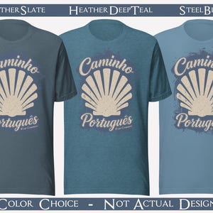 May include: Three short-sleeve crew neck t-shirts in heather slate, heather deep teal, and steel blue. Each shirt features a graphic of a beige scallop shell with the text "Caminho Portugu&ecirc;s" and "Bom Caminho" printed in a distressed font.