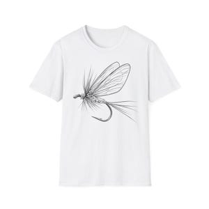 Op de afbeelding: Een wit t-shirt met korte mouwen en een zwart-witte lijntekening van een vliegvissersvlieg in het midden van de borst. De afbeelding toont de gedetailleerde vleugels, het lichaam en de staart van het kunstaas aan een gebogen metalen haak.