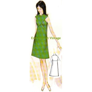 May include: A vintage sewing pattern for a sleeveless dress with a criss-cross bodice and a straight skirt. The dress is green with a white pattern. The pattern includes a front and back view of the dress.