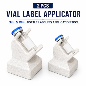 May include: Two beige speckled vial label applicators for 3mL and 10mL bottles. The text reads 2 PCS VIAL LABEL APPLICATOR 3mL & 10mL BOTTLE LABELING APPLICATION TOOL. Each tool features a slanted cradle to hold a glass vial with a blue cap.
