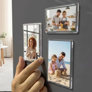 Könnte beinhalten: Transparente magnetische Acryl-Fotorahmen mit Familienfotos. Die rechteckigen Rahmen sind an einer grauen Oberfläche befestigt. Die Fotos zeigen eine Familie beim Kochen, eine Frau mit einer Tasse und einen Vater und eine Tochter am Strand.