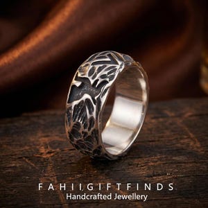 May include: A silver ring with a textured, dark gray pattern. The ring has a wide band and a polished finish. The text "FAHII GIFTFINDS Handcrafted Jewellery" is at the bottom of the image.