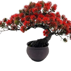 Pu&ograve; includere: Un bonsai artificiale caratterizzato da un tronco scuro, strutturato e curvo, con un fogliame vibrante ad aghi rossi. La pianta &egrave; inserita in un vaso rotondo, semplice e marrone scuro con una finitura liscia, per un aspetto equilibrato.