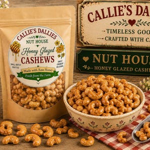 Könnte beinhalten: Ein beigefarbener Beutel mit Callie's Dallies Honig-Cashews mit rundem Etikett, das eine Honigwabe und Text zeigt. Eine Keramikschale mit Honig-Cashews steht neben einer Metallschaufel, einem Honigglas und dekorativen Holzschildern.