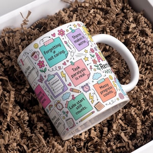 May include: A white ceramic mug featuring a colorful pattern of sticky notes and doodles. Text includes Forgetting not caring, Shame makes it worse, Task paralysis is real, Messy progress counts, Late start still counts, and ADHD Reminders.