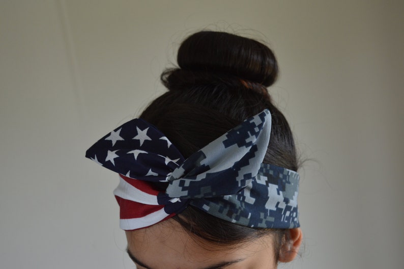 May include: A headband with a blue and white camouflage pattern on one side and a red, white and blue American flag pattern on the other side.