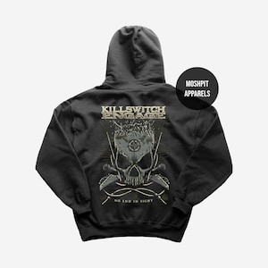 Può includere: Una felpa con cappuccio nera con una grafica sul retro che riporta il testo KILLSWITCH ENGAGE e NO END IN SIGHT. Il design include un'illustrazione centrale di un teschio con chitarre incrociate, un simbolo a bussola e piccole figure.