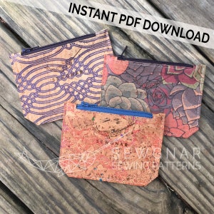 May include: Three cork fabric zipper pouches with different patterns. The pouches are on a wooden surface. The pouches are all the same size and shape. The patterns are a purple and white geometric pattern, a floral pattern with succulents, and a brown and white marbled pattern. The pouches have the text "Sewgnar Sewing Patterns" on them.
