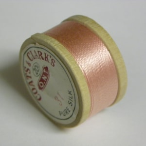 May include: A spool of pale pink Coats & Clark's O.N.T. Pure Silk thread.