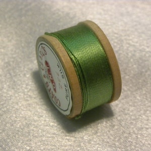 May include: A spool of green Coats & Clark pure silk thread, size 22.