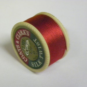 May include: A spool of red Coats & Clark's Silk Twist thread.