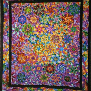 May include: A vibrant, handmade quilt with a kaleidoscope of colorful floral patterns. The quilt features a black border and a rich array of colors, including purple, orange, yellow, and blue. The intricate design showcases a variety of flower shapes.