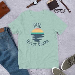 Może przedstawiać: Jasnozielony t-shirt z grafiką zachodzącego słońca w stylu vintage i tekstem "P4L Outer Banks".