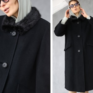 Peut inclure: Un manteau en laine noire avec un col en fourrure noire. Le manteau a une fermeture à boutons et deux poches.