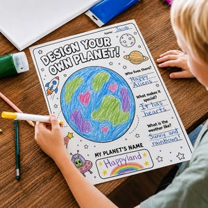 Op de afbeelding: Een wit papieren activiteitenblad met de titel DESIGN YOUR OWN PLANET! met een handgetekende planeet ingekleurd in blauw, groen en roze. Het blad bevat invulvelden met handgeschreven tekst: Jacob, Happy Aliens, It has hearts, Sunny and rainbows!, en Happyland.