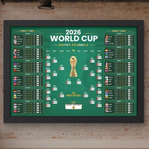 May include: A framed 2026 World Cup match schedule poster with a green background, featuring a central gold trophy illustration, group stage listings with national flags, and a tournament bracket layout for the upcoming football competition.