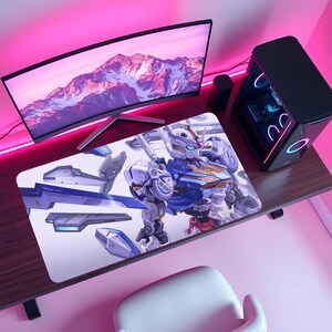 May include: A rectangular desk mat featuring a detailed illustration of a white, blue, and yellow robotic figure with mechanical armor components floating around it. The design is set against a clean white background, providing a high-contrast visual.