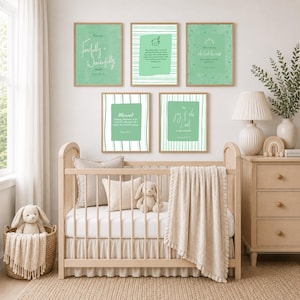 May include: Five rectangular wall art prints in shades of sage green, each featuring white text and illustrations. The prints display various inspirational quotes and scripture references, arranged in a gallery wall layout above a wooden crib.