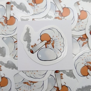 May include: A die-cut sticker featuring a cartoon illustration of a white grub with a tan head, holding a lit cigarette with grey smoke rising. The word "Gub" is written in orange letters near the cigarette. The sticker has a white border.