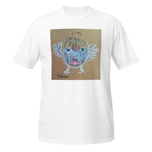 Puede incluir: Camiseta blanca con un dibujo colorido de una cara con detalles en azul, marrón y rojo. La obra de arte incluye una forma central en forma de ojo y detalles en forma de pluma. El nombre "Paloma" está escrito debajo.