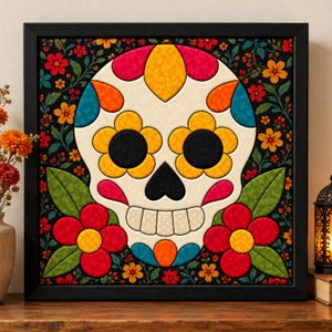 May include: A square framed wall art piece featuring a central cream-colored sugar skull with vibrant yellow, orange, pink, and blue floral accents. The skull is set against a dark background filled with colorful flowers and green leaves.