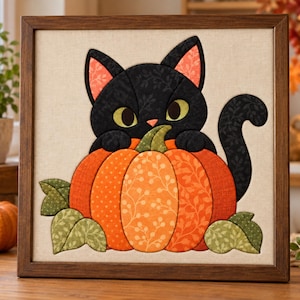 Pode incluir: Uma peça de arte de parede em tecido, quadrada e emoldurada, apresentando um gato preto com grandes olhos verdes sentado atrás de uma abóbora laranja brilhante. O gato tem pelo preto estampado e orelhas laranja. A abóbora é decorada com folhas verdes.