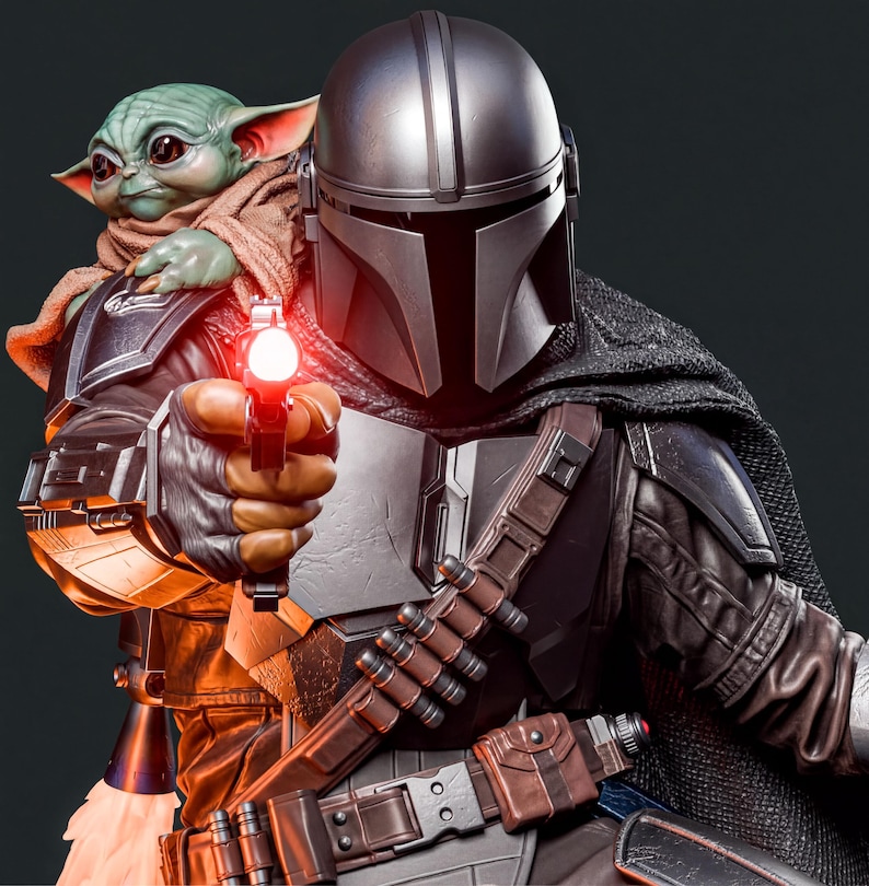 A detailed statue of a character from the Star Wars franchise, holding a gun and pointing it at a smaller figure, likely Baby Yoda, who is wearing a helmet.