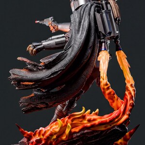 A detailed statue of a character from the Star Wars franchise, with a fiery background and a dynamic pose.