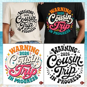 May include: A cream t-shirt and a black t-shirt, each featuring a circular graphic with the text WARNING 2026 COUSIN TRIP IN PROGRESS. The cream shirt has black text, while the black shirt features colorful orange, pink, and teal lettering.