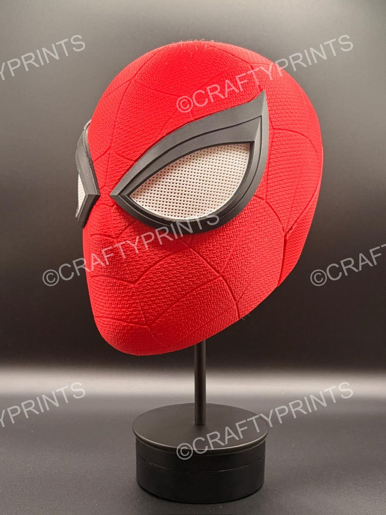 May include: A red textured full-head mask featuring a black web pattern and large, angular black-rimmed eye lenses with white mesh inserts. The mask is mounted on a black display stand. The text CRAFTYPRINTS is visible across the image.