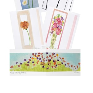 May include: A collection of five greeting cards featuring floral illustrations. Four cards display vertical botanical art, including yellow poppies, black and white ink flowers, an orange poppy, and a colorful bouquet. One horizontal card shows a field of flowers.