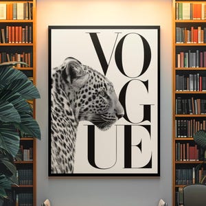 K&ouml;nnte beinhalten: Schwarz-Wei&szlig;-Druck mit dem Wort &bdquo;VOGUE&ldquo; und einem Leopardenprofil. Das Kunstwerk h&auml;ngt &uuml;ber einer Bank in einem Raum mit B&uuml;cherregalen und einer gro&szlig;en Topfpflanze, was ein stilvolles Interieur schafft.