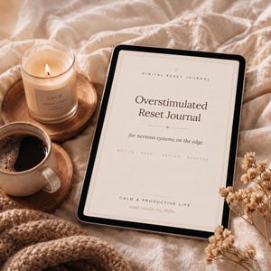 May include: A tablet displaying the text Digital Reset Journal, Overstimulated Reset Journal, for nervous systems on the edge, Notice, Reset, Soften, Restore, Calm & Productive Life, and small rituals, big shifts, alongside a candle and coffee.