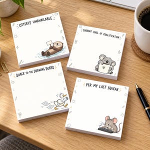 May include: Four square sticky note pads with white paper and animal illustrations. One shows an otter with the text OTTERLY UNAVAILABLE, one a koala with CURRENT LEVEL OF KOALIFICATION, one a duck with QUACK TO THE DRAWING BOARD, and one a mouse with PER MY LAST SQUEAK.