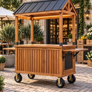 May include: A wooden mobile cart featuring a dark metal gabled roof, a rectangular counter, and vertical slat paneling. The cart is supported by four black wheels with gold-toned hardware and includes two fold-out side shelves for extra surface space.