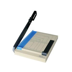 Könnte beinhalten: Ein beigefarbener Papierschneider mit einer schwarzen, klappbaren Schneideklinge, einer blauen Kunststoff-Ausrichtungshilfe und einer schwarzen Papierklemme. Die Basis enthält aufgedruckte Messmarkierungen und Rasterlinien für präzises Arbeiten.