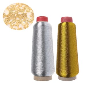 Può includere: Due rocche coniche di filo metallizzato, una argento e una oro, ciascuna sormontata da un tappo rosso. Sopra, un inserto circolare mostra un primo piano di un motivo in pizzo floreale dorato, evidenziando la consistenza e la lucentezza.