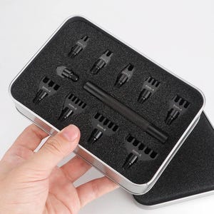 Puede incluir: Un juego de cinceles de costura de cuero de metal negro y un mango a juego guardados en una caja rectangular de metal plateado con inserciones de espuma negra. Los cabezales están etiquetados con los tamaños 4mm-2, 4mm-4, 4mm-6, 5mm-4, 5mm-6 y 6mm-6.