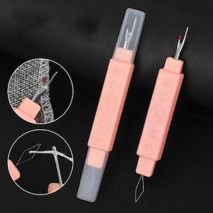 May include: Two light pink seam rippers with protective clear caps. Each tool features a metal blade with a red safety ball at the tip. One ripper is shown with a threader attachment, while circular insets demonstrate the tool cutting fabric.
